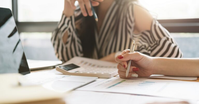 Close up of businessman or accountant working on calculator to calculate business data, accountancy