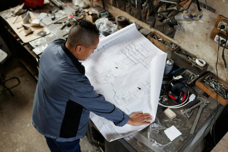 Woman Inspecting Plans At Factory